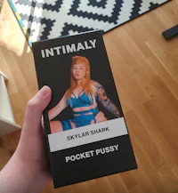 a woman holding up a box of intimately pocket pussy